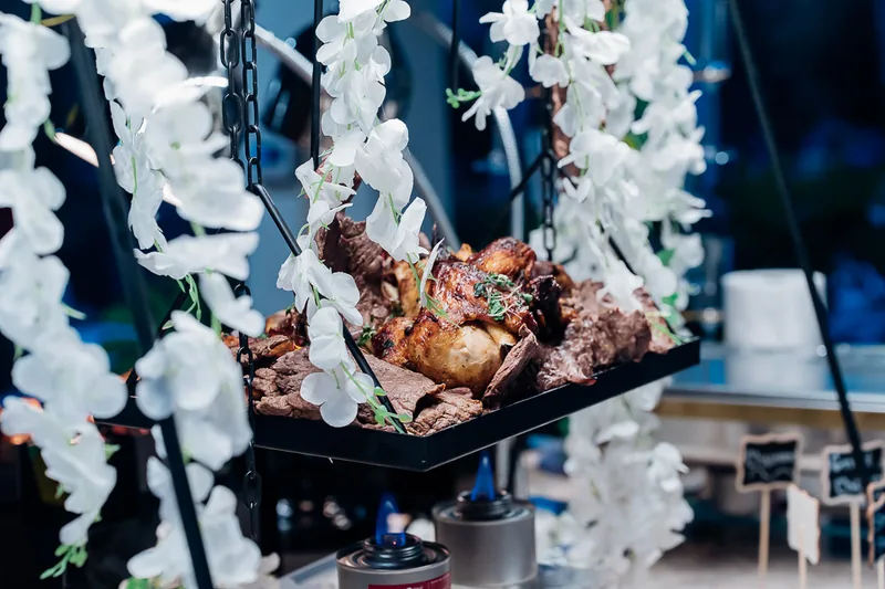 Hanging display of meats framed with white florals