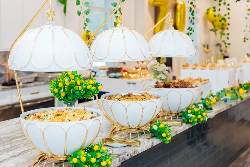 White and gold buffet vessels styled with lemons and greenery