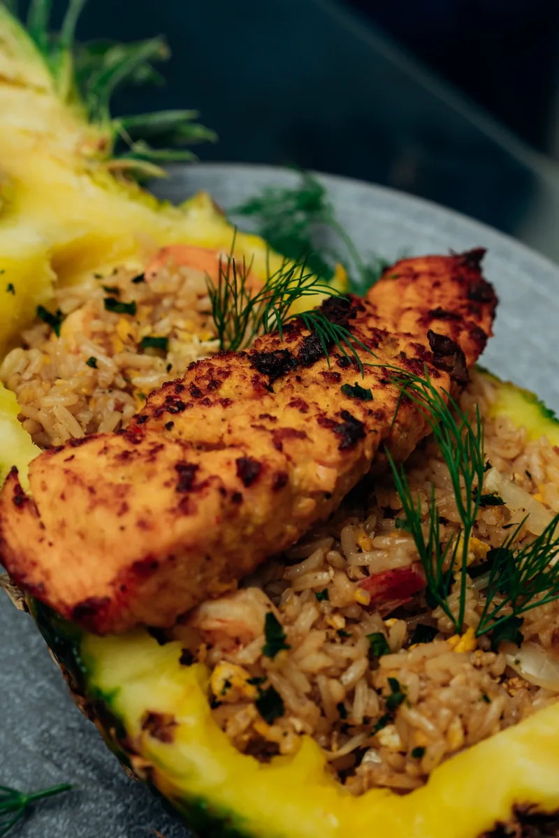 Salmon and rice served in a halved pineapple