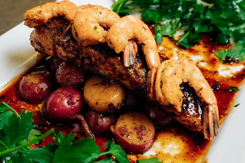 Glazed salmon topped with shrimp, served with roasted potatoes