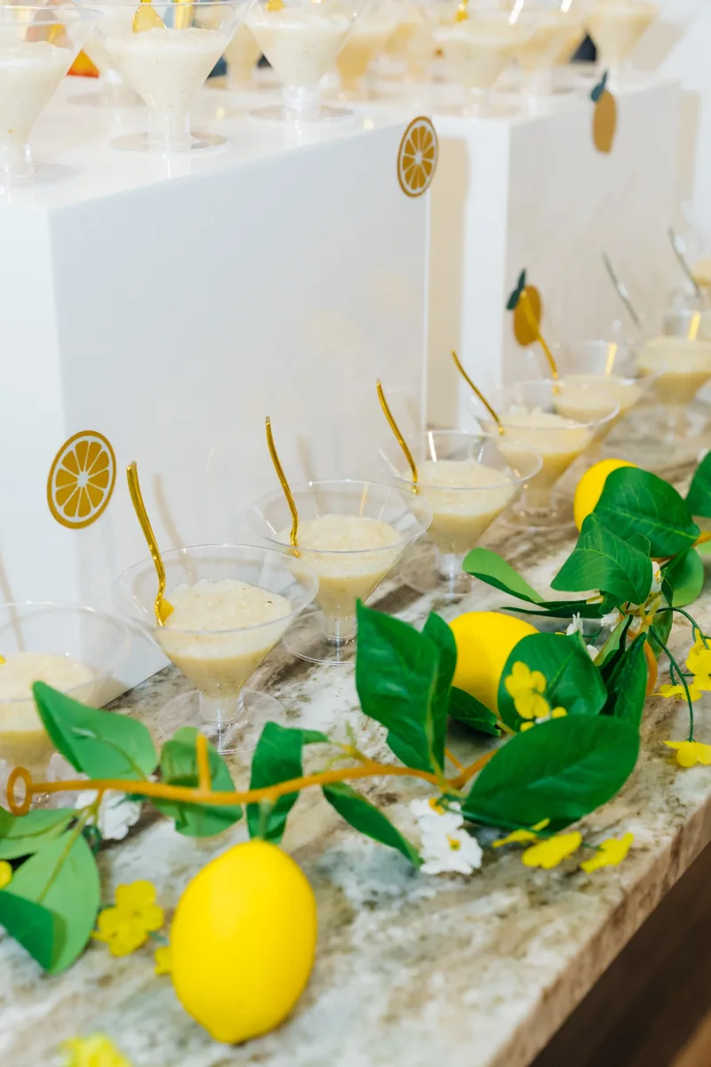 Lemon-themed display of individual glasses with gold spoons