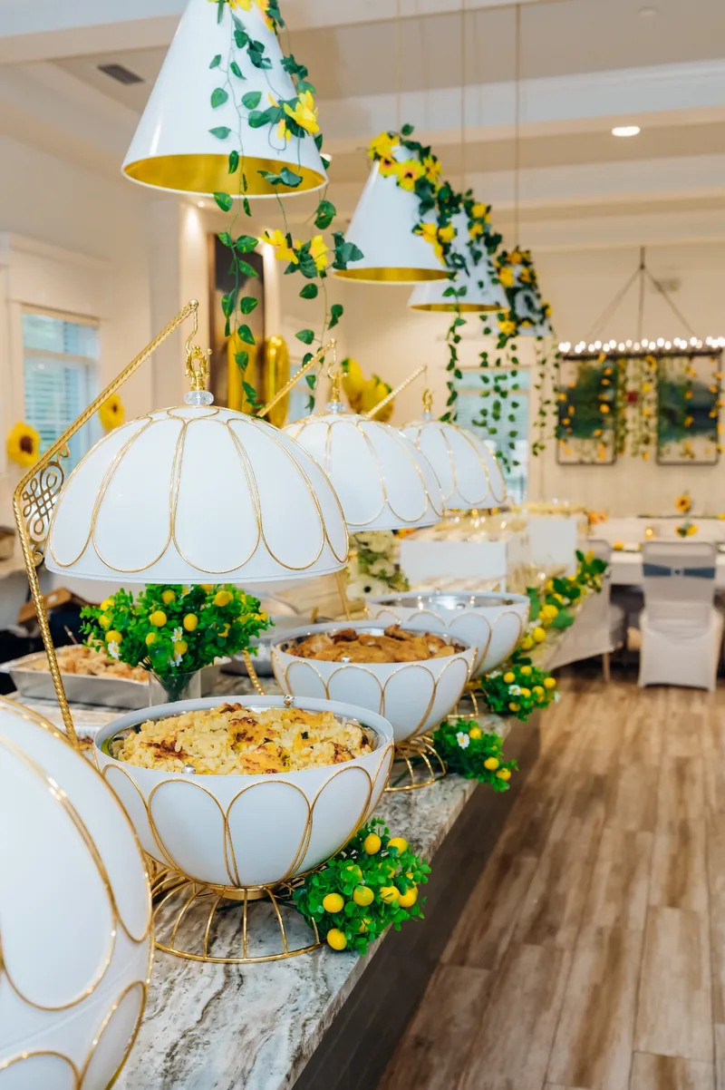 Long white and gold buffet line with lemon and floral styling